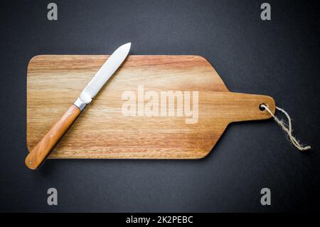 Traditionelles Taschenmesser auf einem Holzschneidebrett Stockfoto