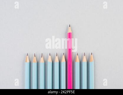 Blaue Bleistifte in einer Reihe, ein pinker Stift steht hervor, sei anders, Führungs- und Teamwork-Konzept Stockfoto