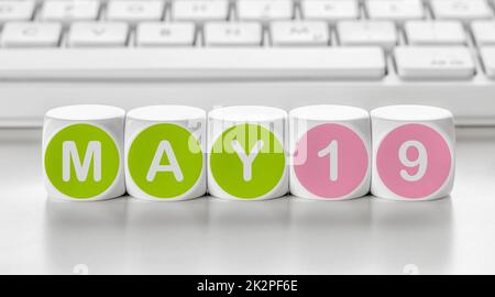 Buchstabenwürfel vor einer Tastatur - Mai 19 Stockfoto