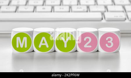 Buchstabenwürfel vor einer Tastatur - Mai 23 Stockfoto