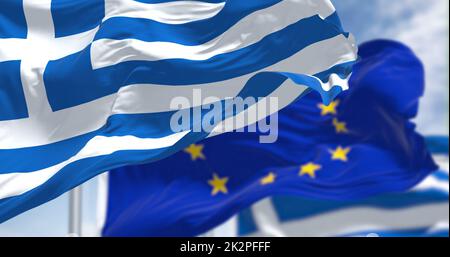 Detail der im Wind winkenden Nationalflagge Griechenlands mit verschwommener eu-Flagge im Hintergrund an einem klaren Tag Stockfoto