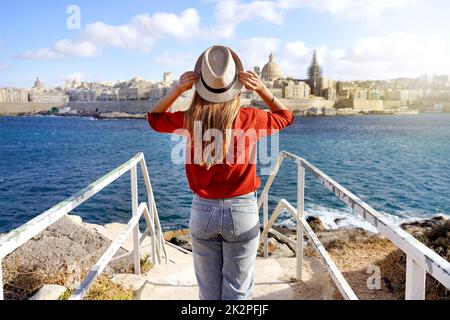 Urlaub Malta. Rückansicht des schönen Mädchen genießen Blick auf Valletta Stadtlandschaft mit dem blauen Wasser des Mittelmeers. Stockfoto