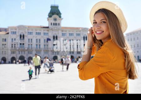 Porträt einer glücklichen, unbeschwerten Frau im Strohhut dreht sich um und lächelt zur Kamera Stockfoto