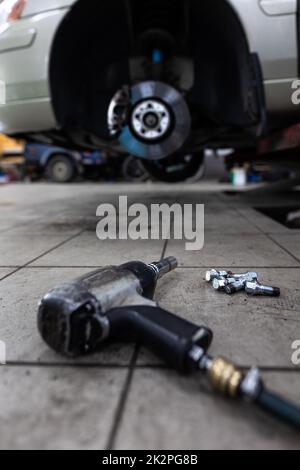Fahrzeug in einer Garage für Wartung, Öl-/Reifenwechsel (flaches Bild mit DOF-Farbtönen) Stockfoto
