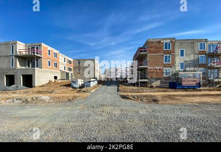 Modernes und neues Apartmentgebäude. Mehrstöckige moderne, neue und stilvolle Wohnblöcke. Selektive Freiheitsgrade, Fokus auf das Gras mit verschwommenen Gebäuden im Hintergrund (reichlich Platz für Kopien) Stockfoto