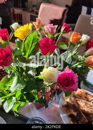 Verschiedene Rosen in Glasvase Stockfoto