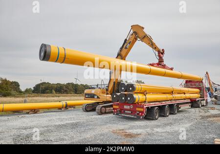 23. September 2022, Schleswig-Holstein, Brunsbüttel: Ein Kran hebt auf der Rohrleitungsbaustelle für den geplanten schwimmenden Flüssiggas-Terminal ein Rohr aus einem Transporter in Vakuumrichtung. Foto: Georg Wendt/dpa Stockfoto