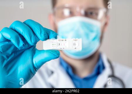 Positives Testergebnis durch Verwendung eines Schnelltestgeräts für COVID-19. Stockfoto