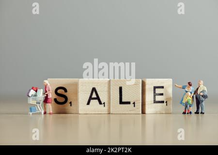 Das Wort "Sale" wurde mit Holzfliesen geschrieben Stockfoto