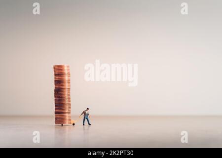 Arbeiter mit einem Handwagen voller Münzen Stockfoto