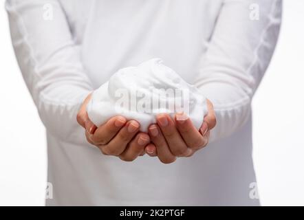 Eine Frau mit Seifenblasen auf weißem Hintergrund. Stockfoto