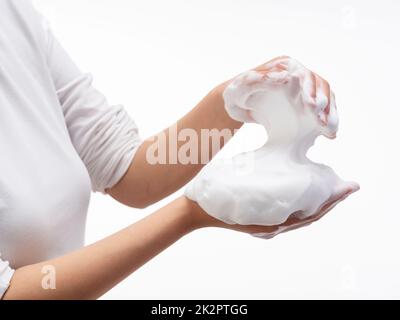 Eine Frau mit Seifenblasen auf weißem Hintergrund. Stockfoto