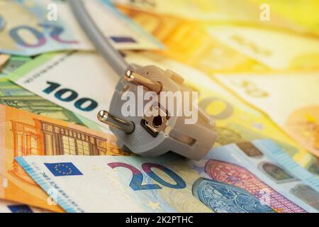 Elektrischer Stecker auf Euro-Banknoten Stockfoto