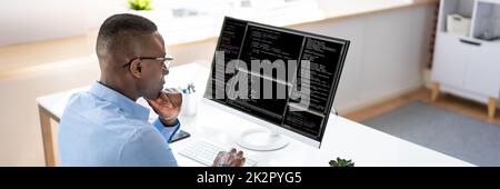 Afroamerikanischer Coder Mit Computer Am Schreibtisch Stockfoto