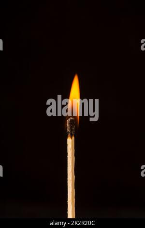 Brennendes Streichholz auf schwarzem Hintergrund Stockfoto