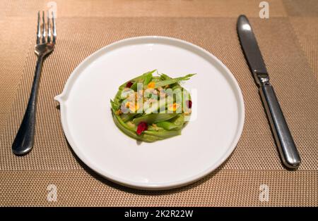 Grüner Spargel saisonal, Guacamole und Himbeeren. Vorspeisen-Menü im Abendgericht auf dem Tisch serviert. Stockfoto