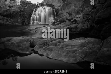 Ein Schwarz-Weiß-Foto eines kleinen Wasserfalls im Litchfield-Nationalpark in Westaustralien Stockfoto