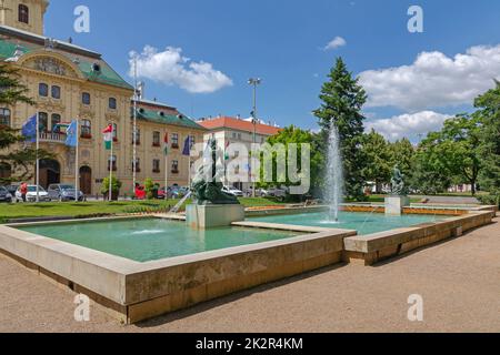 Szeged, Ungarn - 16. Juni 2021: Wasserbrunnen-Wahrzeichen am Szechenyi Square Park vor dem Rathaus. Stockfoto