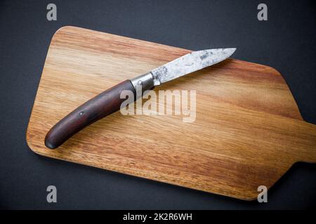 Traditionelles Taschenmesser auf einem Holzschneidebrett Stockfoto