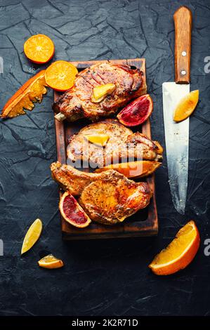 Steak auf dem Knochen gegrillt mit Zitrusfrüchten. Stockfoto