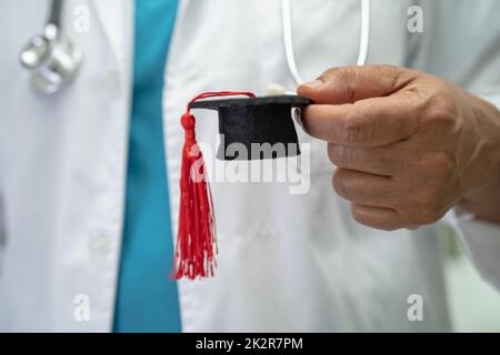 Asiatische Arzt Studie lernen mit Abschluss GAP Hut in Krankenhausstation, clever hell Genie Bildung Medizin Konzept. Stockfoto