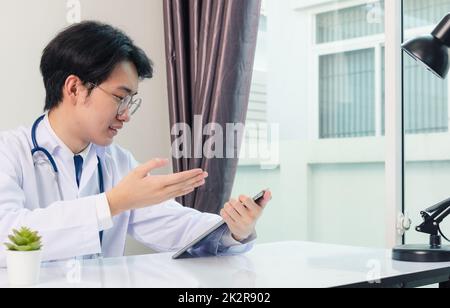 Arzt Mann lächeln Verwenden Sie einen modernen, intelligenten, digitalen Tablet-Computer erklären Sie den Patienten Krankheitssymptome Stockfoto