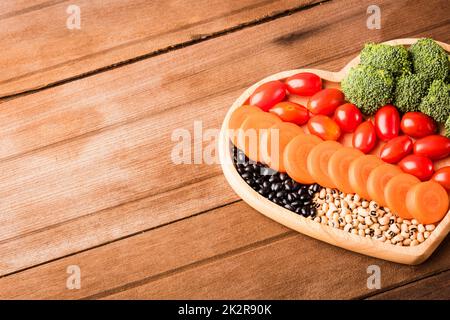 Frisches Bio-Obst und -Gemüse in Herzplattenholz Stockfoto