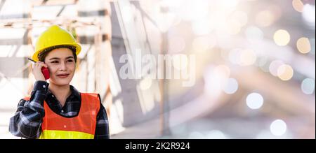 Asiatischer Ingenieur, Vorarbeiter, Architektin, Arbeiterin auf einer Baustelle, die mit Radio spricht Stockfoto