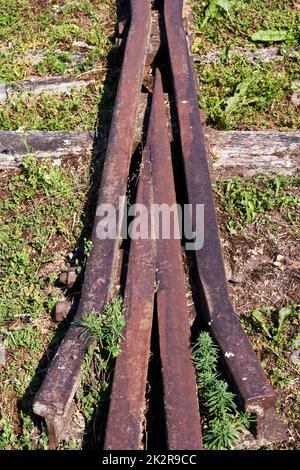 Eine Vertikale einer verlassenen Eisenbahnstrecke, umgeben von Gras Stockfoto