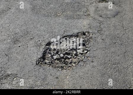 Schlaglöcher auf der Straße Stockfoto