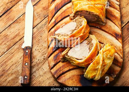 Wellington-Schweinefleisch, Schweinefilet, gebacken mit Pilzen in Blätterteig. Stockfoto