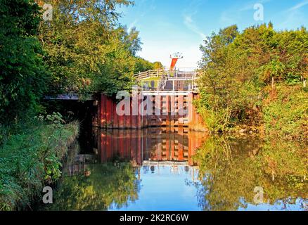 Das Becken des Ribble Link mit den Schleusentoren des Lancaster-Kanals, die sich im Wasser spiegeln, und der Ribble Link-Wasserkanal links Stockfoto