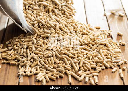 Holzpellets, Biokraftstoff auf Holztisch. Ökologischer Brennstoff aus Biomasse. Erneuerbare Energiequelle. Stockfoto