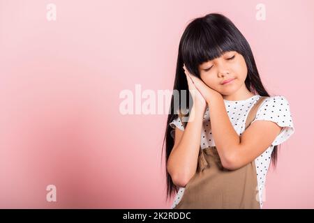 Asiatische kleine Kind 10 Jahre alt stehen mit Händen versiegelt vorgeben, er schläft geschlossen Augen Stockfoto