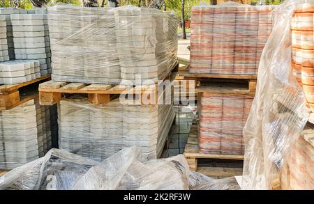 Nahaufnahme: Die neuen Pflasterplatten werden übersichtlich auf Paletten gestapelt. Reparatur von Gehwegen und Ersatz von Pflasterplatten. Wiederaufbau der städtischen Infrastruktur Stockfoto