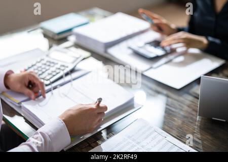 Zwei Kollegen Aus Dem Geschäftsbereich, Die Steuern Berechnen Stockfoto