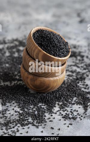 Indisches Gewürz Schwarze Kreuzkümmel (Nigella sativa oder Kalonji) Samen in Holzschüsseln aus der Nähe Stockfoto