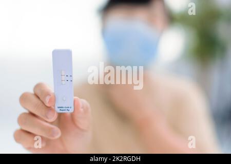 Frau mit Rapid Antigen-Testkit mit positivem Ergebnis während des COVID-19-Abstrichtests Stockfoto