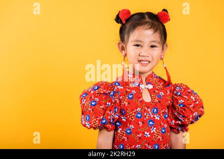 Glücklich asiatische chinesische kleine Mädchen lächeln trägt rote cheongsam Stockfoto
