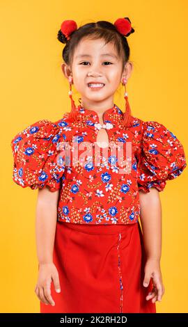 Glücklich asiatische chinesische kleine Mädchen lächeln trägt rote cheongsam Stockfoto