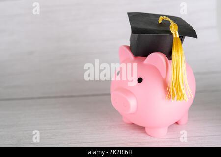 Sparschwein mit Abschlusskappe, Business Finance Bildung Geld sparen Stipendium Konzept. Stockfoto