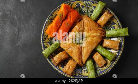 Ein Tablett mit türkischem Gebäck, darunter Baklava, Knafeh – ein Käseteig aus dem Nahen Osten, getränkt in süßem Sirup auf Zuckerbasis Stockfoto