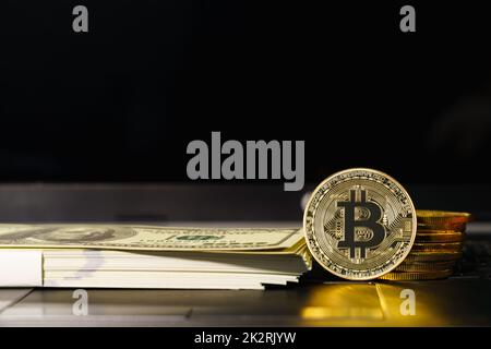 Bitcoins, Münzen und Banknoten auf Tastaturcomputern Stockfoto