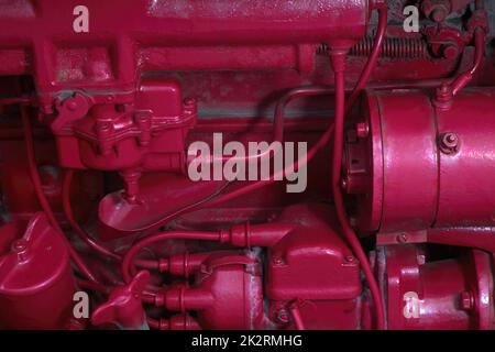 Rot lackierter Motor Alte Maschinenteile industrieller Hintergrund Antiquitätstechnologie Mechanische Motordetails Stockfoto