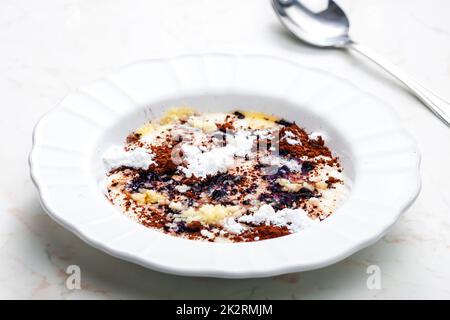 Grießbrei mit Kakao, Zucker und geschmolzener Butter Stockfoto