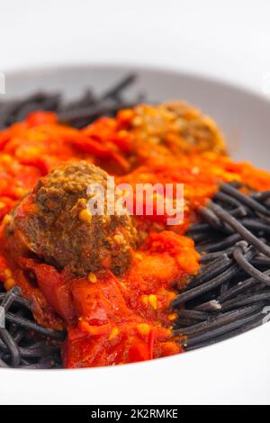Schwarze Spaghetti mit Tomatensauce und Fleischbällchen Stockfoto