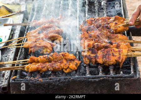 Gegrilltes Hähnchen auf einem heißen Herd mit Rauch, der herauskommt Stockfoto