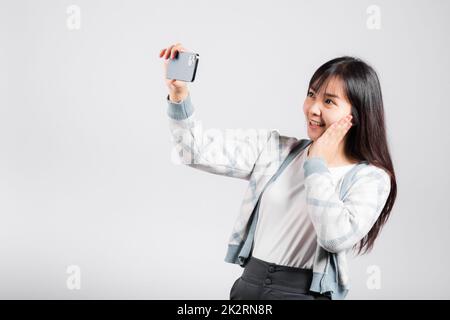 Frau begeistert, mit dem Smartphone Selfie-Fotos von der Frontkamera aufzunehmen Stockfoto