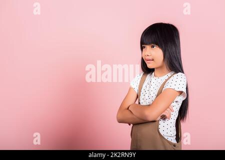 Asiatisches kleines Kind, 10 Jahre alt, lächelnd mit verschränkten Armen Stockfoto