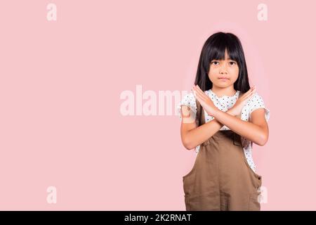 Asiatische kleine Kind 10 Jahre alt zeigt zwei Hände Kreuz Arme sagen kein X-Zeichen Stockfoto